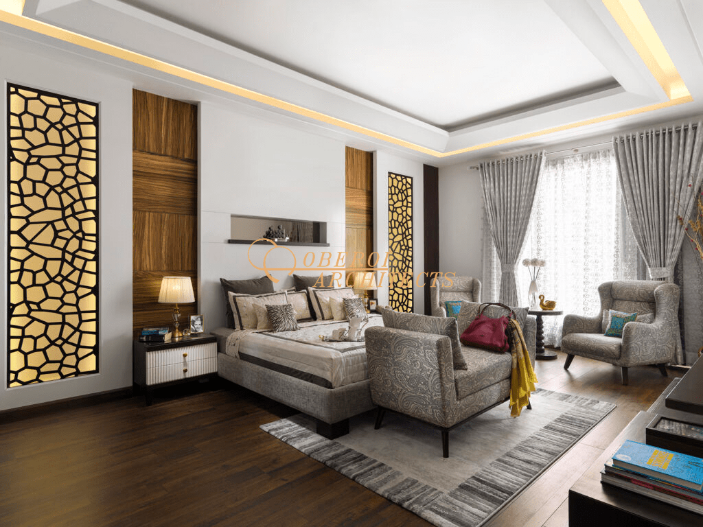 Luxury bedroom suite with armchairs, dark wood floors, and gold accents