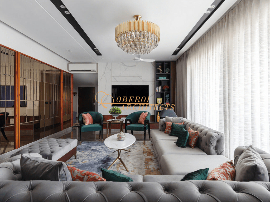 Formal living room with grey sofas, emerald chairs, marble feature wall, and chandelier