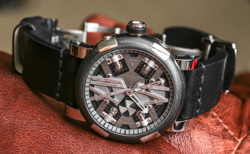 Industrial-style dark grey and silver watch with complex face on textured brown leather