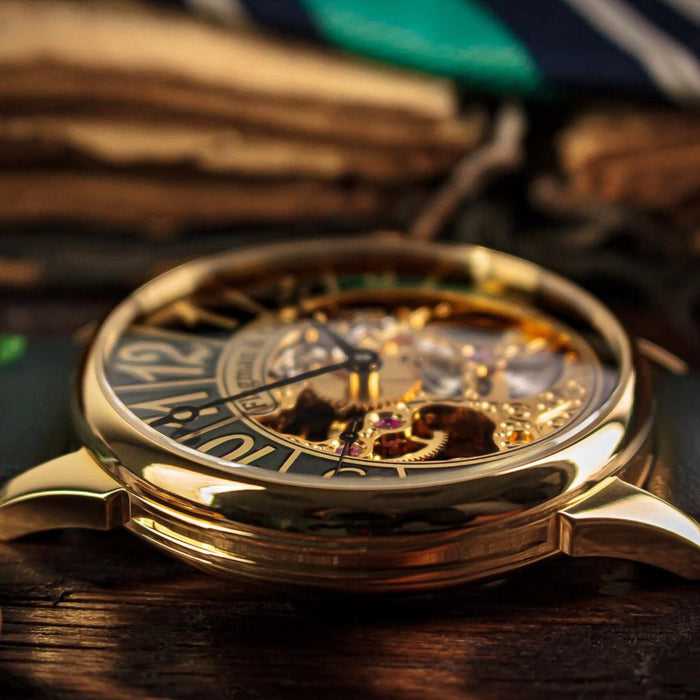 Vintage gold skeleton watch with dark green face resting on warm brown wood