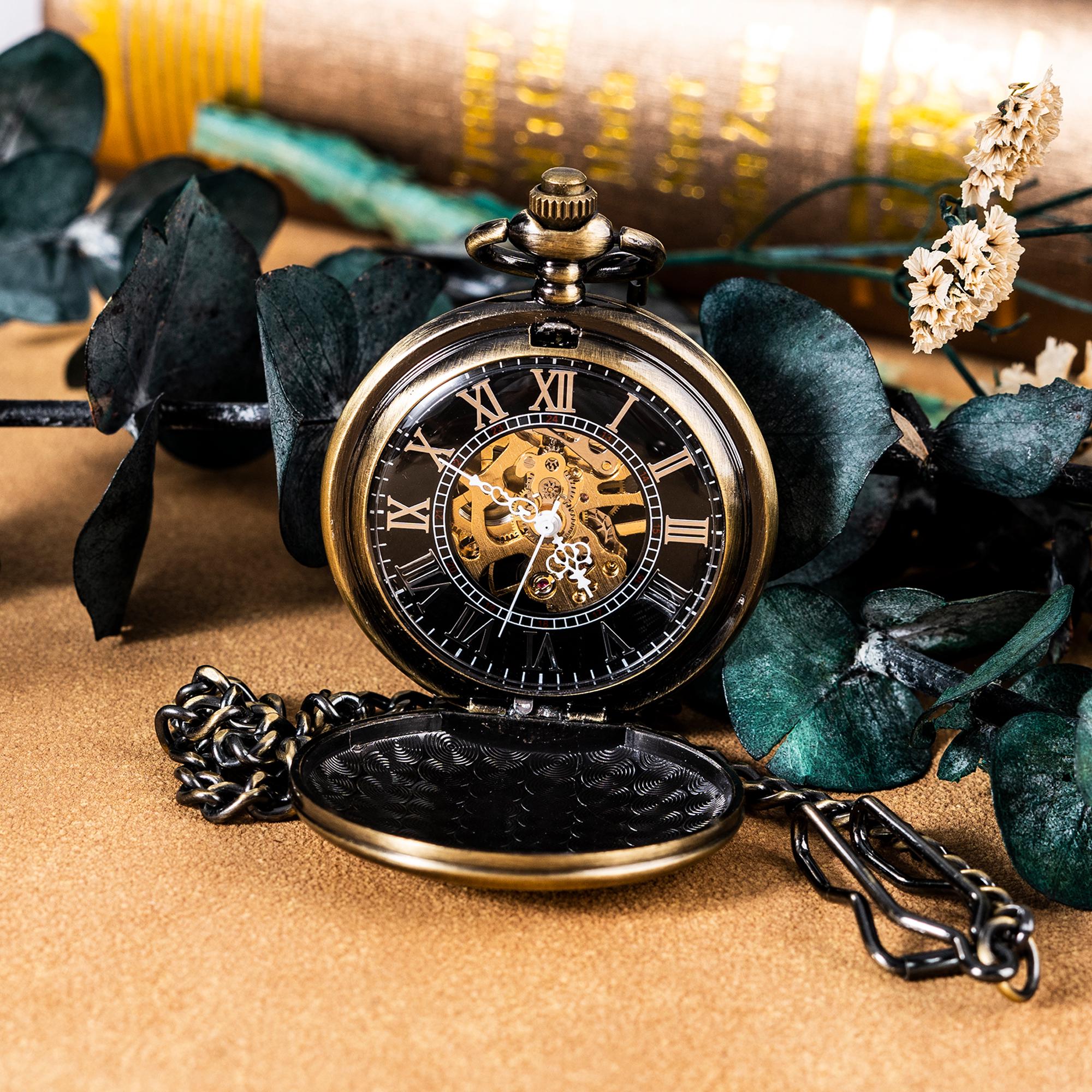 Bronze pocket watch with visible gears among green leaves and dried flowers
