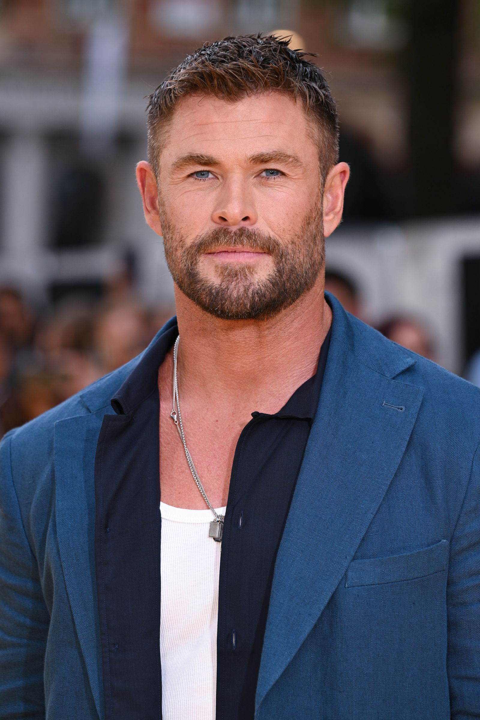 Close-up portrait with brown hair, beard, and blue jacket