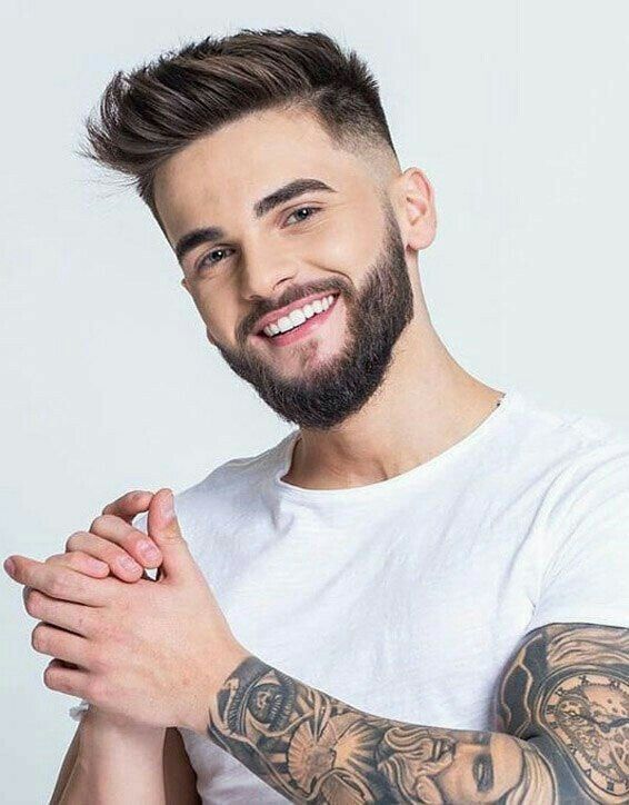 Smiling man with beard and sleeve tattoos