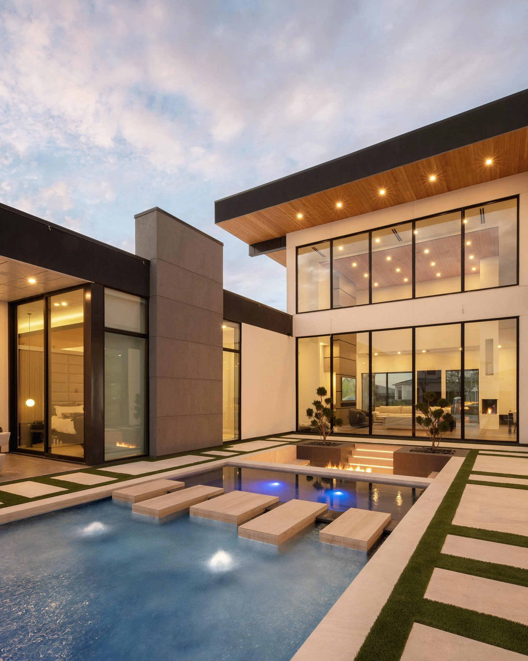 Azure Glass House with blue pool, stepping stones, and large glass windows
